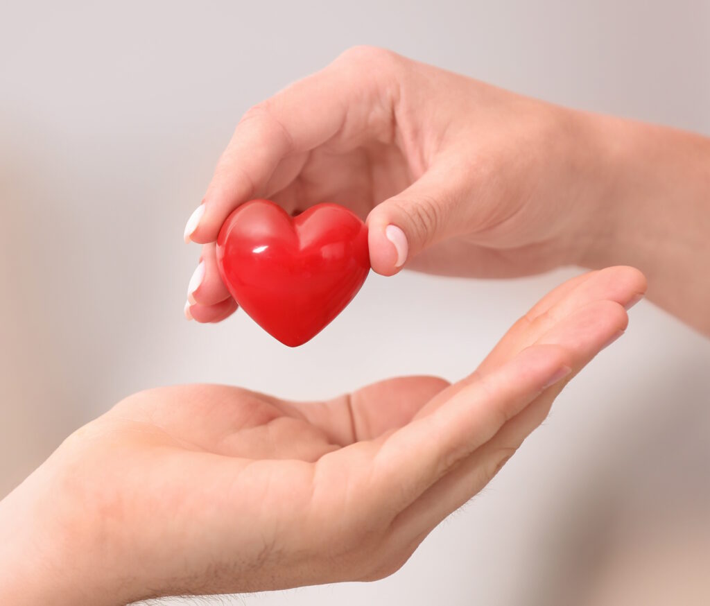 Eine Hand legt ein Herz in eine andere
